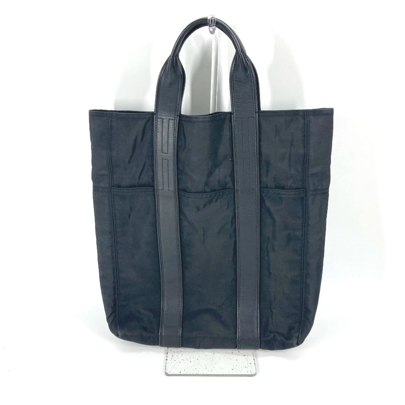 Nylon tote bag from Hermes: Nylon tote bag from Hermes Nylon tote bag from Hermes features a sleek black design with an inner zipper pocket and open outer pocket, making it a versatile and practical accessory. The bag measures