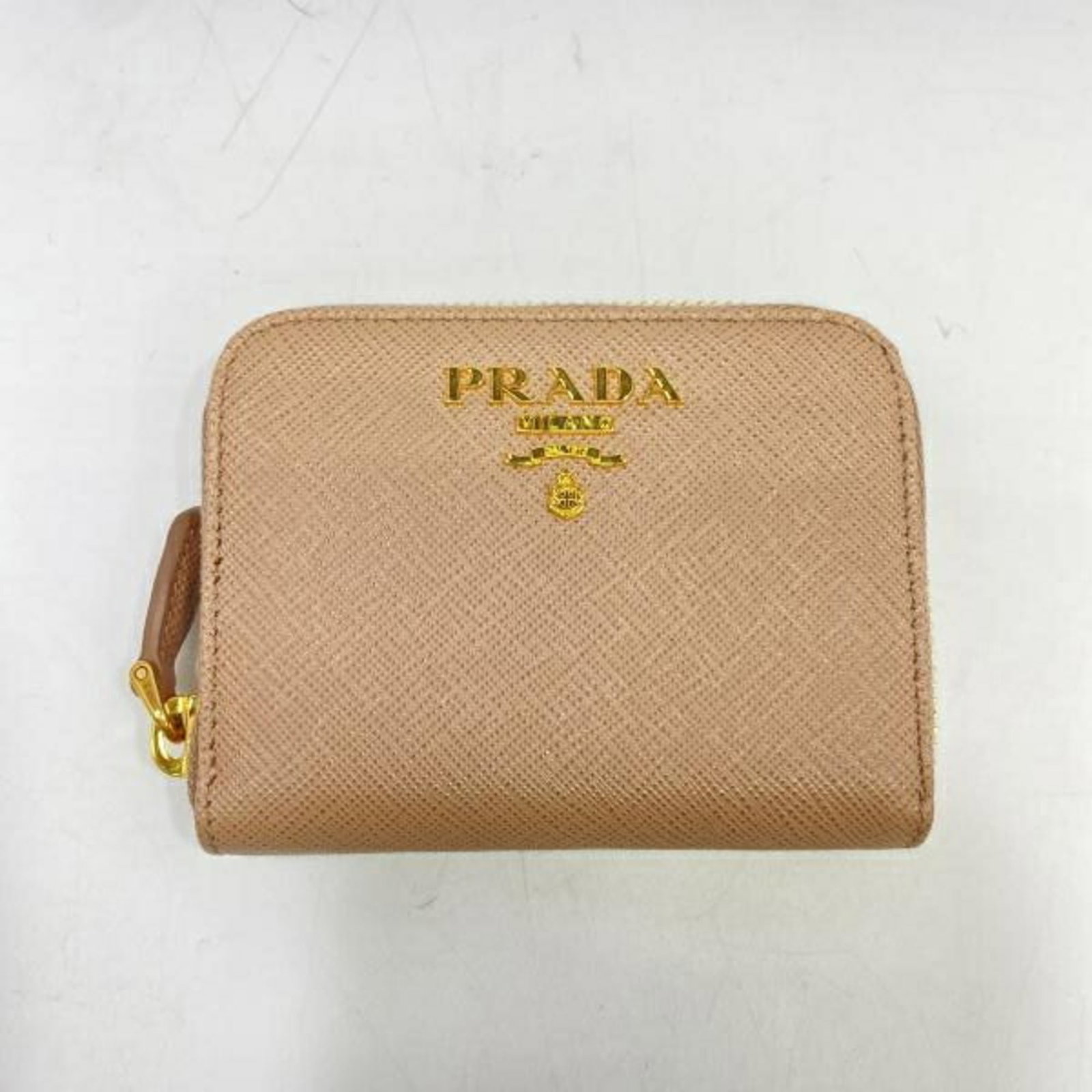 Coin purse by Prada: Coin purse by Prada This Prada coin purse boasts a chic pink beige hue and compact size, measuring 8cm x 10.5cm x 2cm. Its sleek design makes it a stylish accessory for everyday use. The signature log