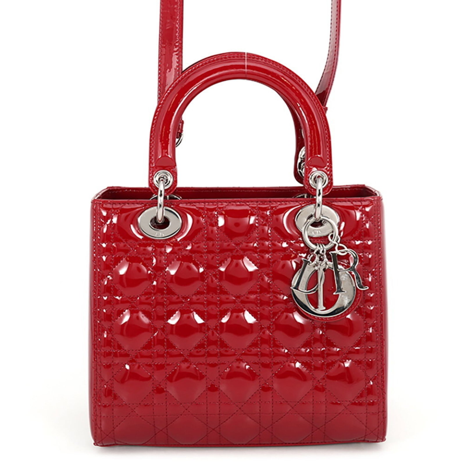 Patent leather handbag by Christian Dior: Patent leather handbag by Christian Dior Patent leather by Christian Dior in bold red color, featuring silver hardware and a zipper closure. This Lady Dior handbag boasts sleek design with a patent fi