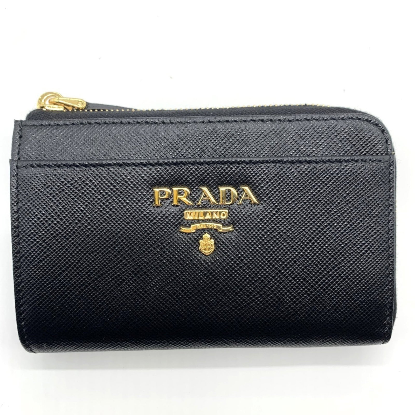 Prada Coin Purse/ Coin Case Leather: Prada Coin Purse/ Coin Case Leather Saffiano leather coin purse/coin case from Prada, featuring a sleek black design with a zipper closure. Measuring 8cm x 13cm x 2.5cm, it provides a compact and styl