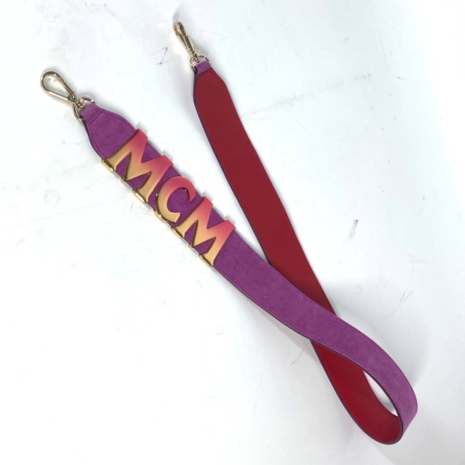 Mcm Strap Leather: Mcm Strap Leather Suede leather strap with gold and purple accents, measuring 93cm in length. This MCM strap features a classic design with a mix of luxurious materials. The gold and purple hues add