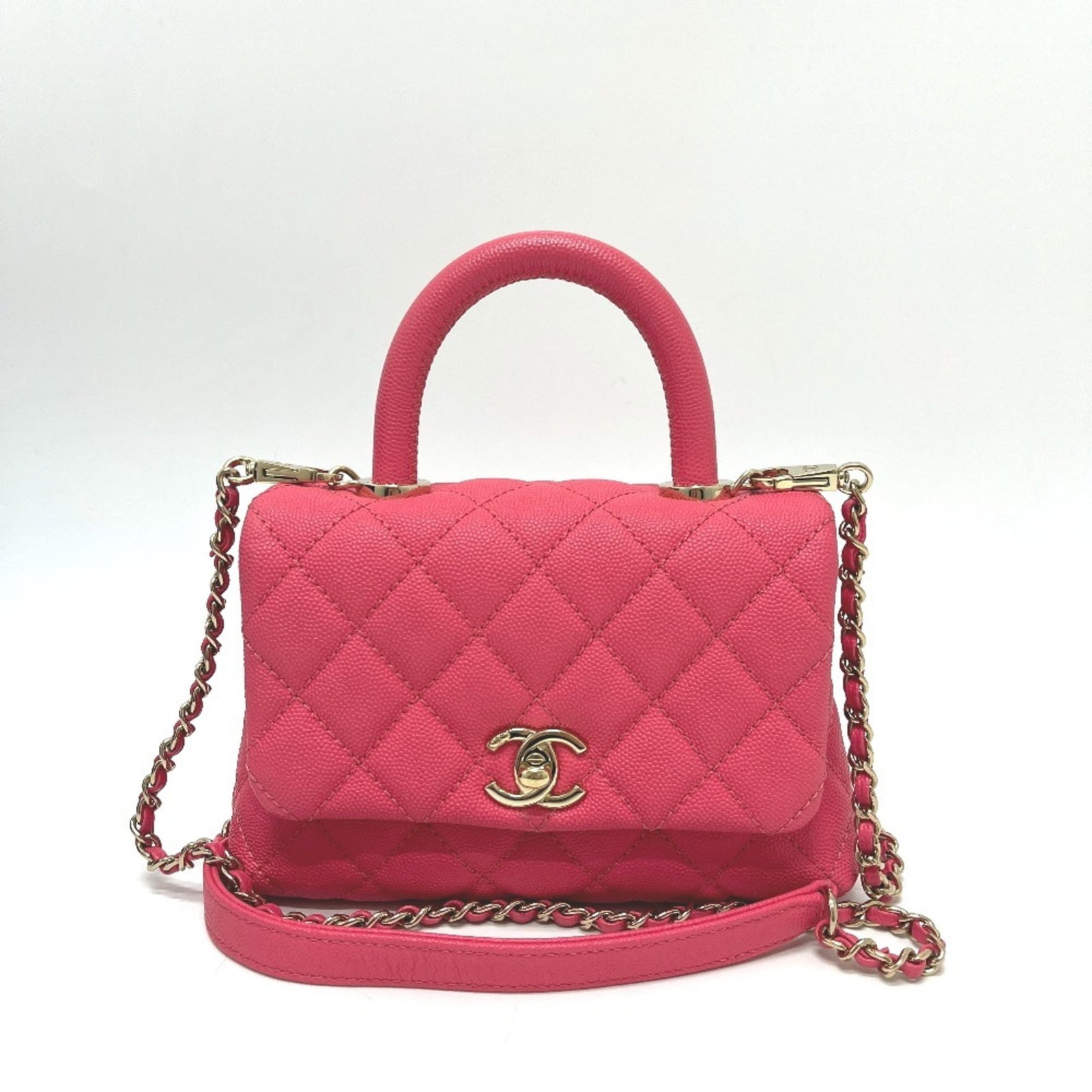 Calfskin Handbag by Chanel: Calfskin Handbag by Chanel Calfskin Handbag by Chanel boasts its striking coral pink hue and sleek design, crafted from high-quality grained calfskin. Measuring 12.5cm x 18cm x 9cm, this stylish
