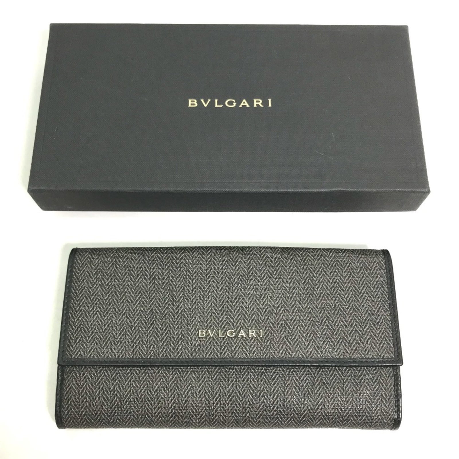 Bvlgari Long Wallet (Bi-Fold) Pvc Leather: Bvlgari Long Wallet (Bi-Fold) Pvc Leather PVC and leather combine in sleek, modern design with the Bvlgari Long Wallet (Bi-Fold). Measuring 10cm x 18.5cm x 3cm, it features a sturdy bi-fold structure