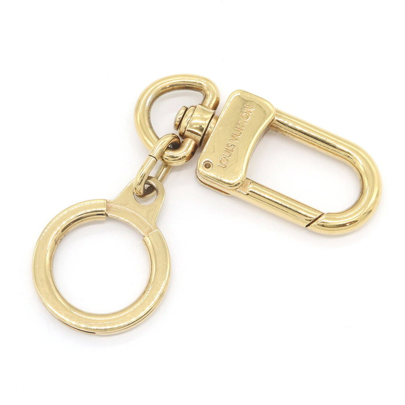 Keyring Metal By Louis Vuitton: Keyring Metal By Louis Vuitton Gold metal keyring from Louis Vuitton, featuring a compact design with a size of 8cm x 2.4cm. Made from high-quality metal, this charm is a stylish accessory that adds a