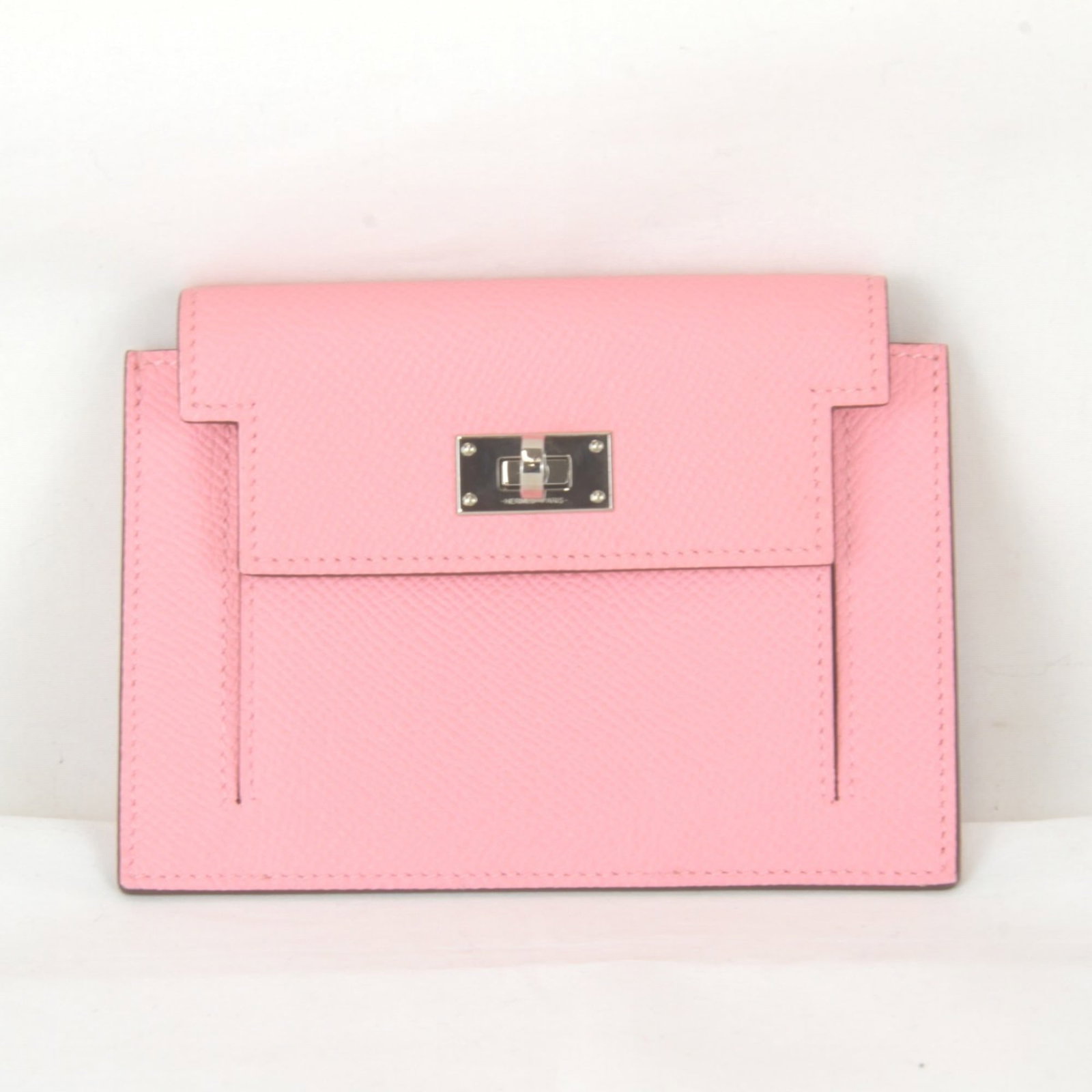 Leather purse coin case Hermes: Leather purse coin case Hermes This pink leather coin case from the iconic Kelly line features a sleek turn lock closure and measures 9.5cm x 13cm x 1.5cm. Made from high-quality leather, it boasts a 