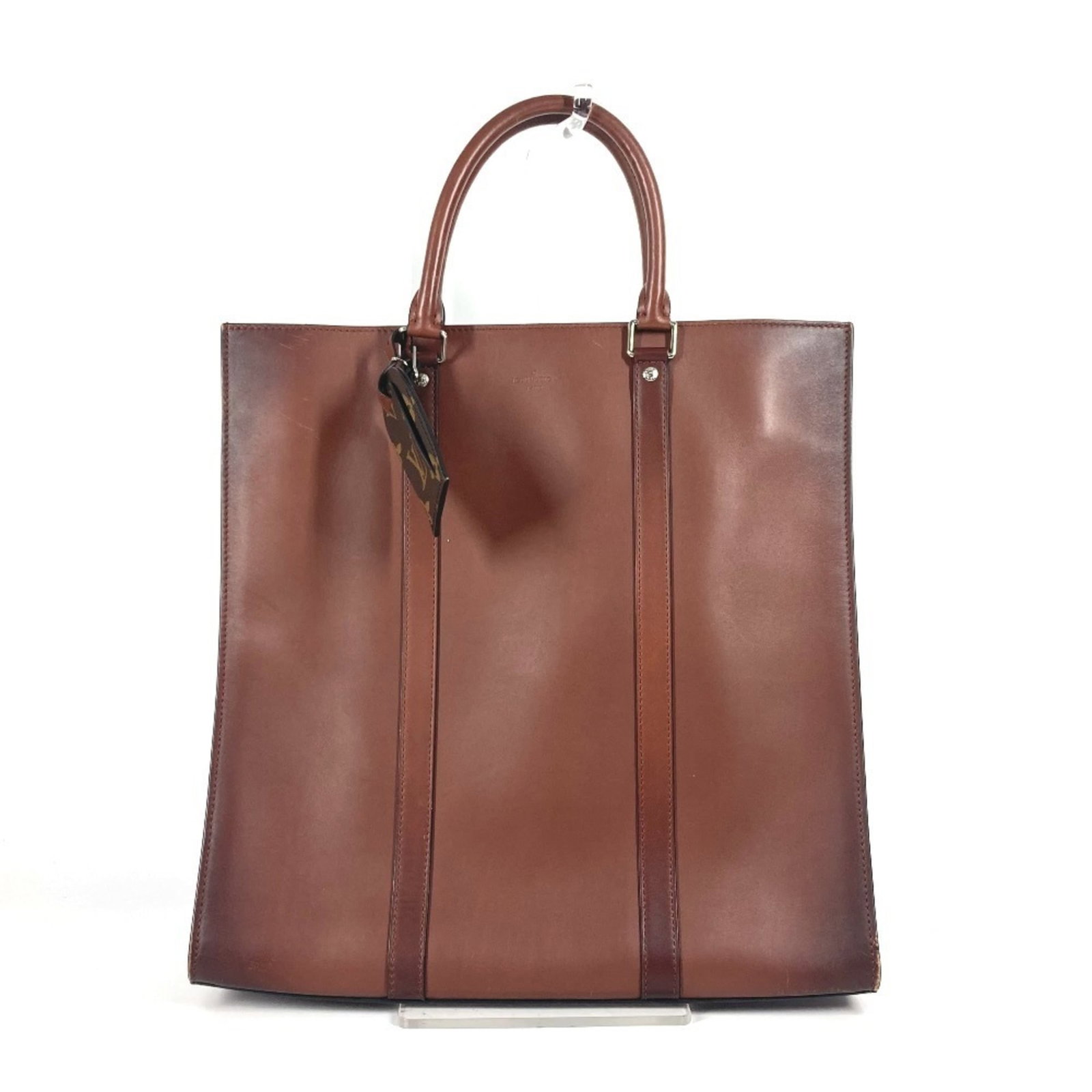Nomade leather bag tote handbag vuitton Louis: Nomade leather bag tote handbag vuitton Louis Nomade leather bag tote handbag vuitton Louis features genuine Nomade leather in brown color, an open closure, and measures 35cm x 35.5cm x 8.5cm. The