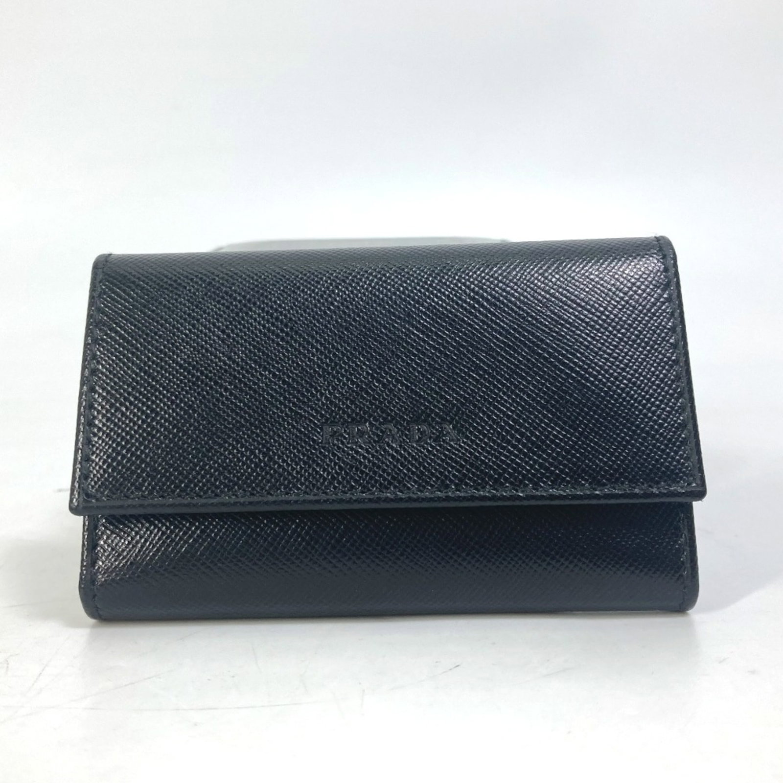 Keycase by Prada: Keycase by Prada Keycase by Prada, crafted from other materials in sleek black. Measuring 9cm x 6cm (3.5" x 2.4") and 3.5cm x 2.4" when opened, this compact case is designed to keep your keys organize