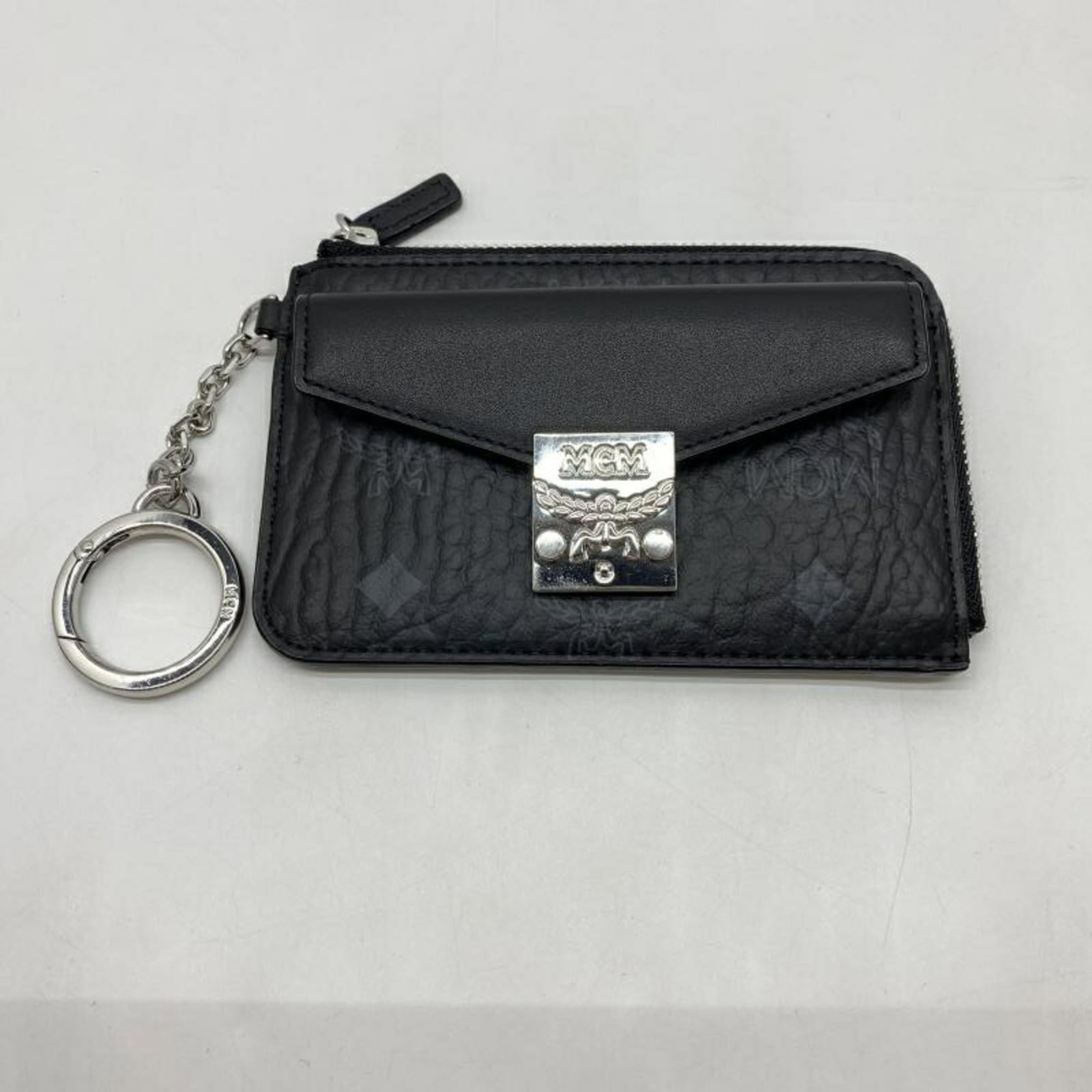 Mcm Coin Purse/ Coin Case: Mcm Coin Purse/ Coin Case Black MCM coin purse/coin case with sleek design and compact size, measuring 8.5cm x 12.5cm x 0.31''. Made from a sturdy material, it features a simple yet stylish aesthetic 