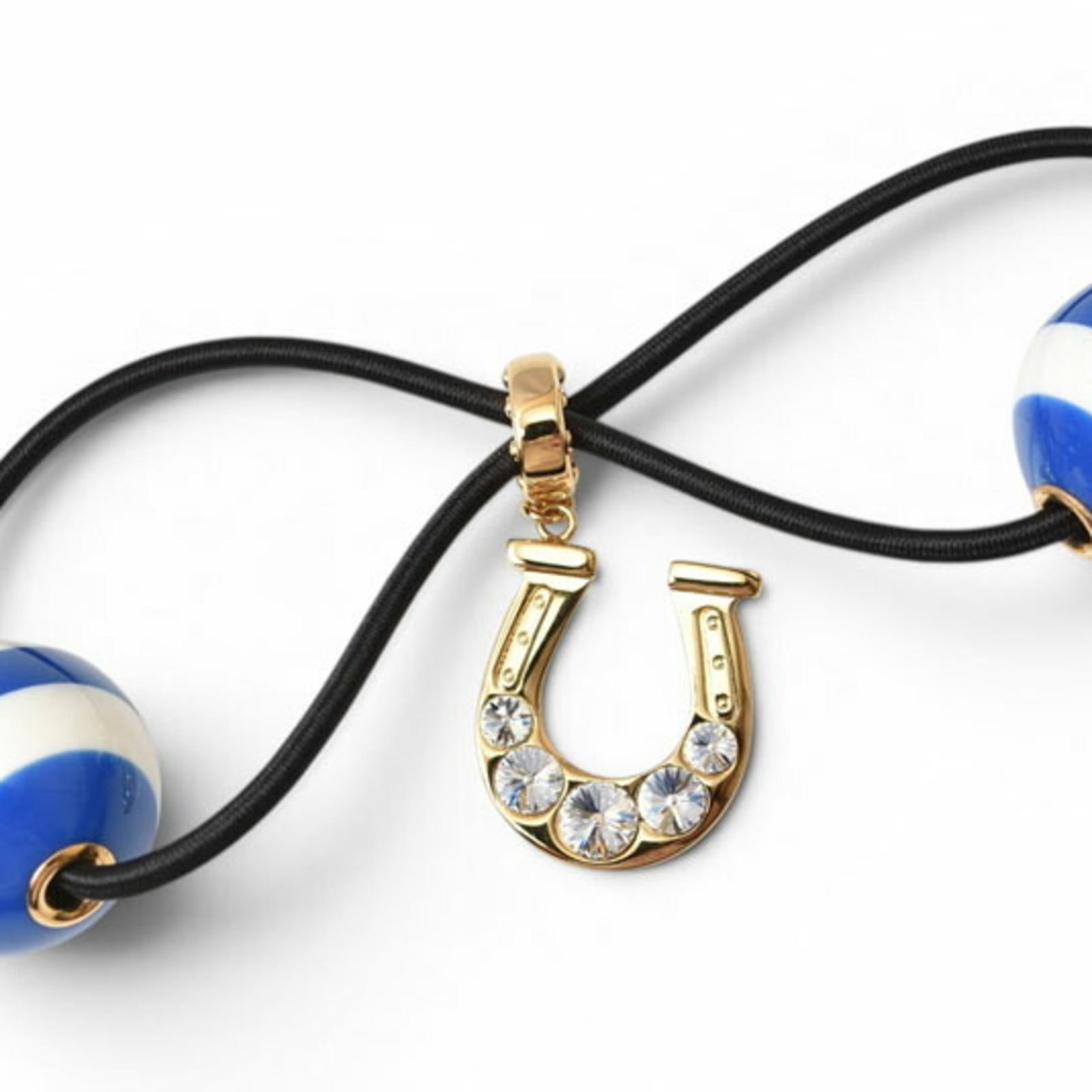 Miu Hair Tie Brass Plastic: Miu Hair Tie Brass Plastic Miu Miu's Brass Plastic Hair Tie boasts a striking blue and white design, featuring a crystal and rhinestone stone. The hair tie measures 2.5cm x 13.8cm in size, making it