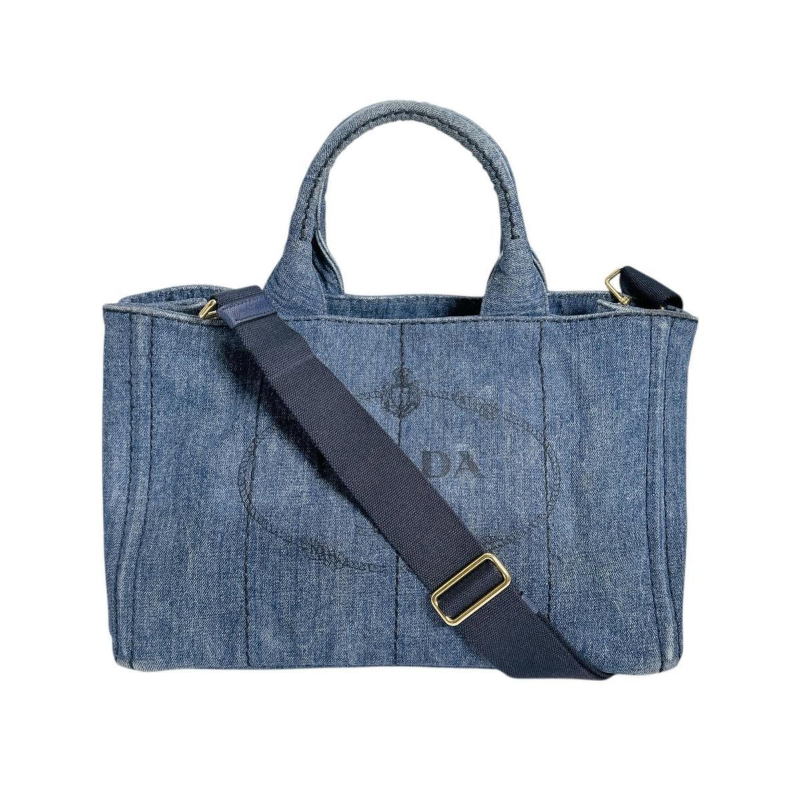 Denim Tote Bag Prada: Denim Tote Bag Prada Denim tote bag from Prada, crafted with a sturdy denim material and featuring a blue color. The bag measures 23cm x 33cm x 22cm and comes with a shoulder strap for added convenien