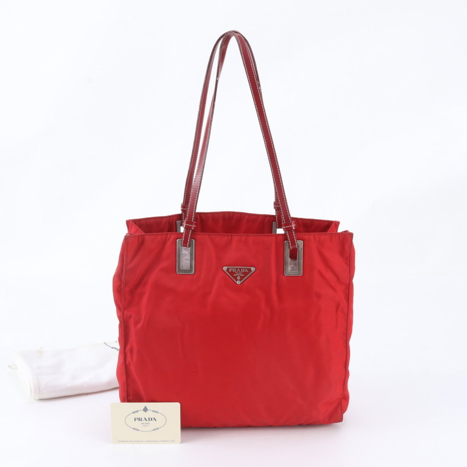 Nylon Leather Prada Tote Bag: Nylon Leather Prada Tote Bag Nylon and leather combine in this striking Prada tote bag, available in red. Measuring 27cm x 28cm x 9cm, it features a unique blend of materials and bold color. Its