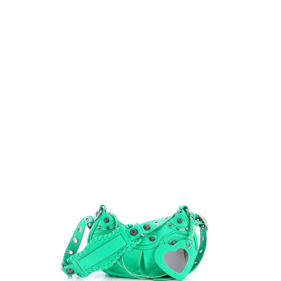 Le Cagole Giant Studs Leather XS Balenciaga Bag: Le Cagole Giant Studs Leather XS Balenciaga Bag Le Cagole Giant Studs Leather XS Balenciaga Bag features a striking green exterior with minor creases, and measures 5.5" in height, 10" in width, and