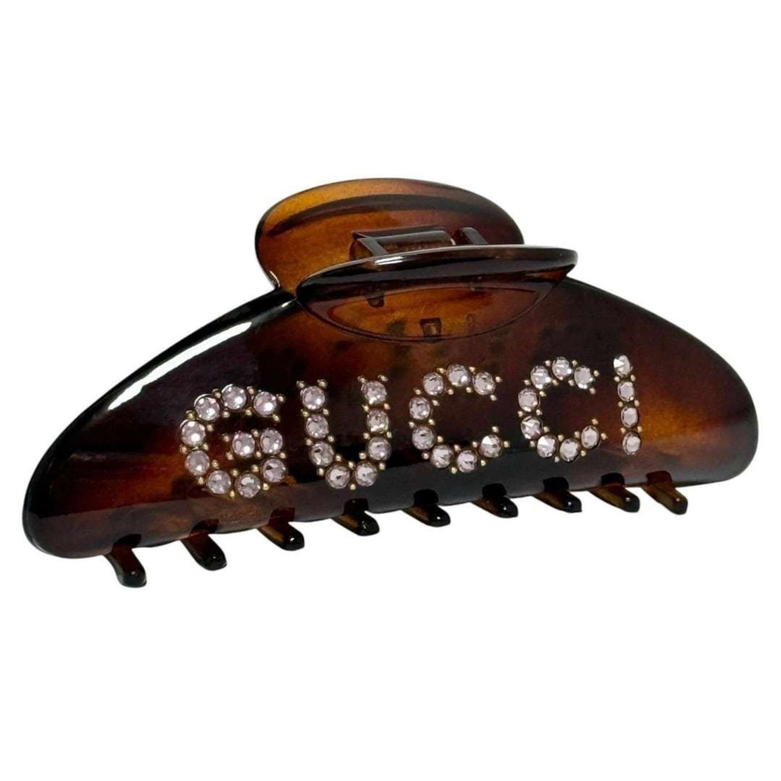 Hair clip by Gucci: Hair clip by Gucci This Gucci hair clip boasts sleek, understated design with a rich brown hue. Measuring 4.5cm x 11.5cm, its compact size belies its sophisticated style. The subtle signature adds a