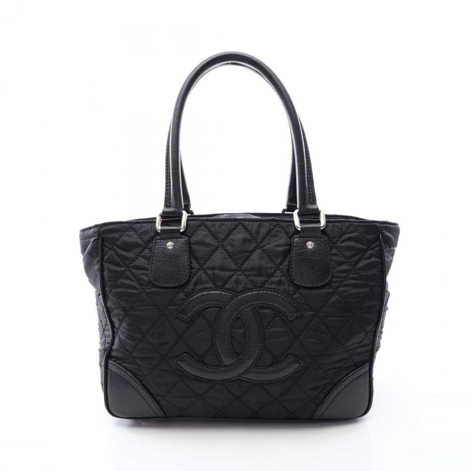 Chanel Handbag Tote Bag Nylon Leather: Chanel Handbag Tote Bag Nylon Leather Chanel's iconic tote bag combines nylon and leather in sleek black, finished with silver hardware. Measuring 26cm x 33cm x 14cm, this stylish accessory is designe