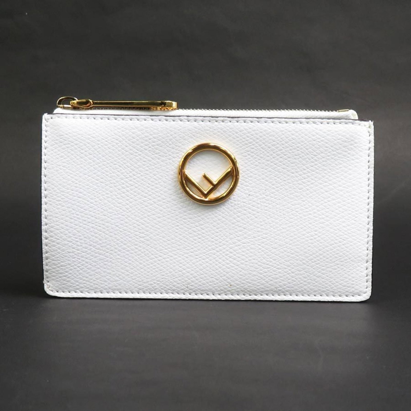 Coin purse leather case by Fendi: Coin purse leather case by Fendi The Fendi coin purse leather case is a sleek and sophisticated accessory made from high-quality white leather. Measuring just 7.5cm x 13.3cm x 1.5cm, it features a com