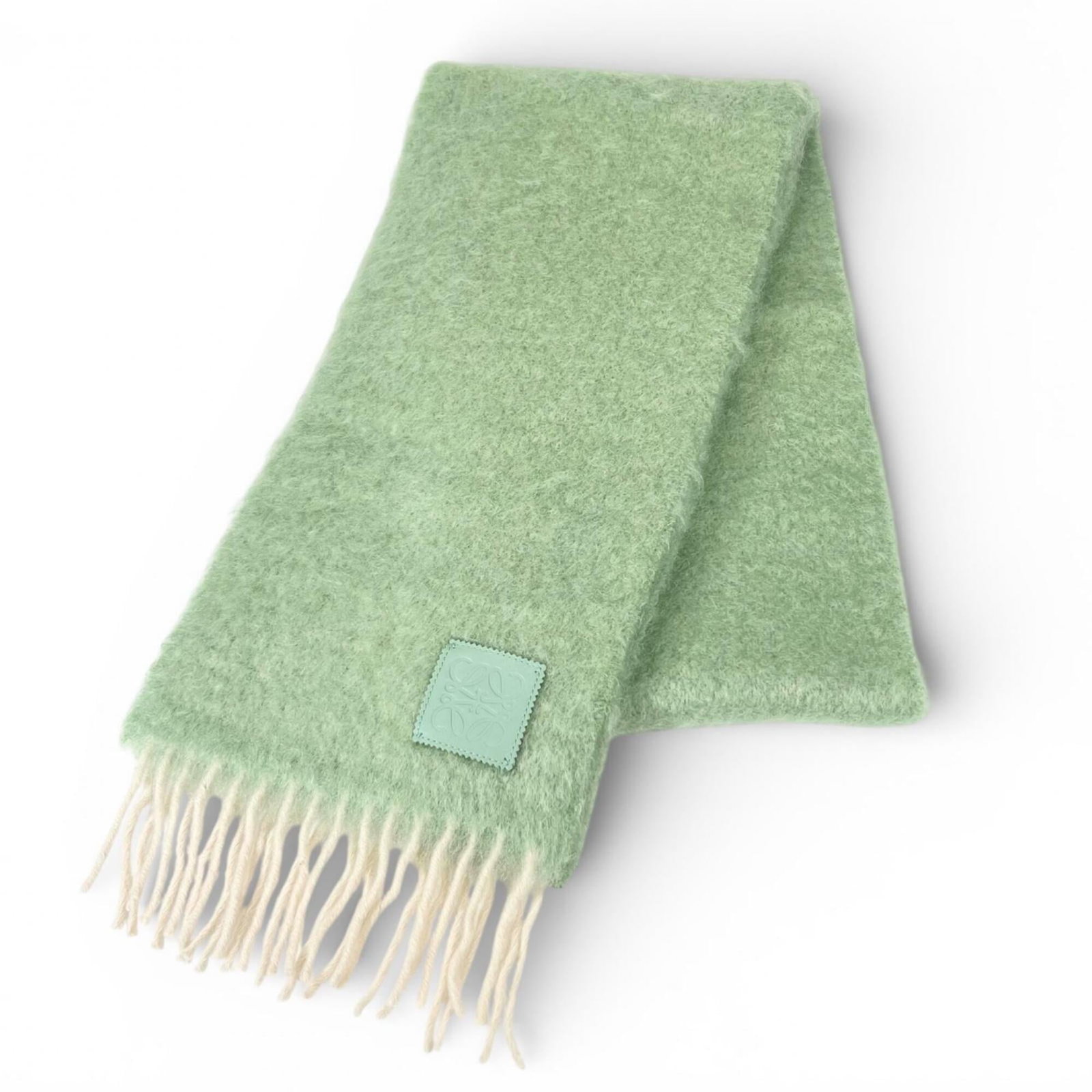 Mohair Shawl Loewe 50% Wool 2% Nylon: Mohair Shawl Loewe 50% Wool 2% Nylon The Loewe shawl boasts a striking green hue, crafted from a unique blend of mohair, wool, and nylon. Spanning 2 meters in length, this statement piece offers a dra