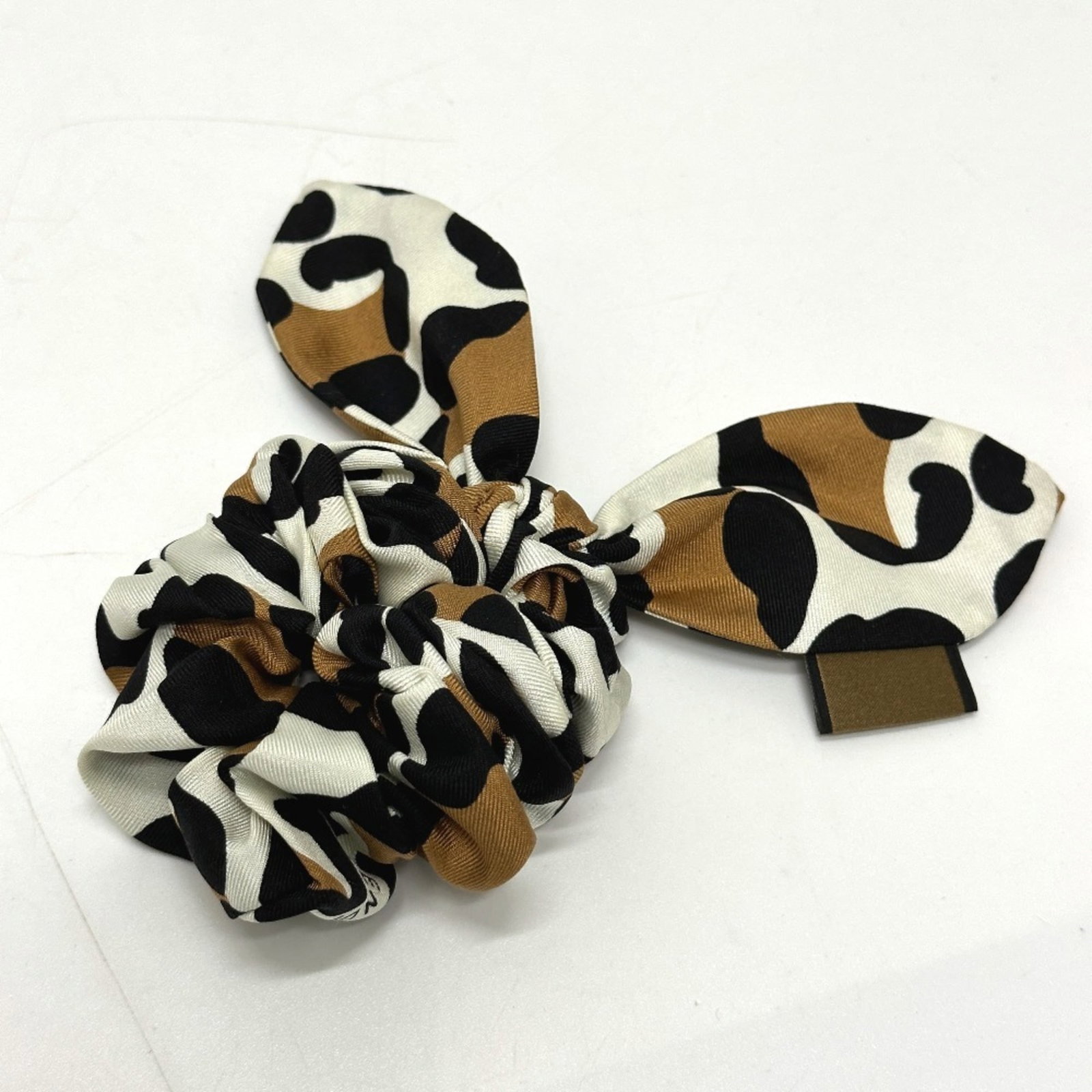 Silk hair tie by Fendi: Silk hair tie by Fendi Silk hair tie by Fendi, featuring a luxurious brown silk material and a charming size. This elegant accessory showcases the brand's signature style with its understated charm.
