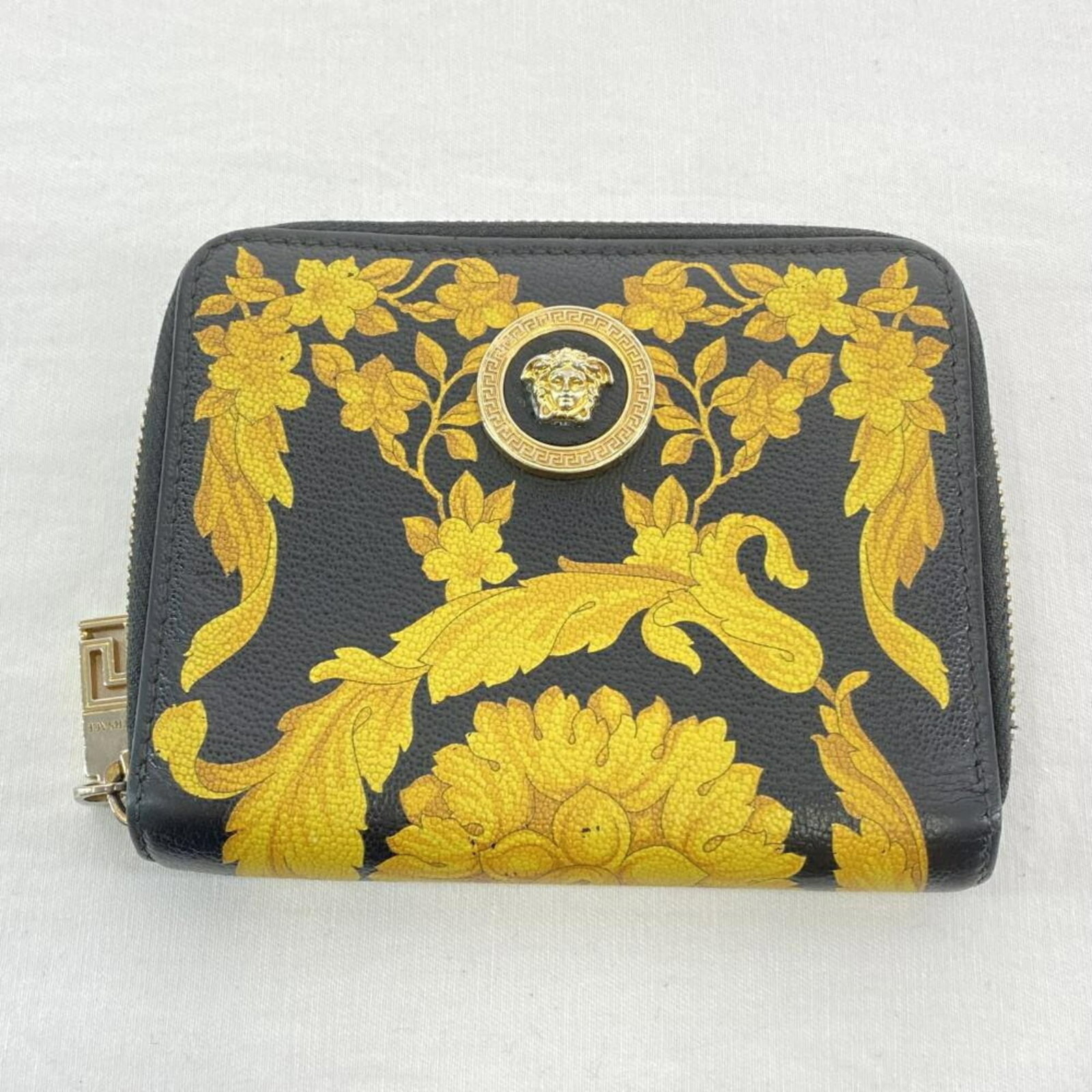Coin purse by Versace: Coin purse by Versace Versace's sleek black coin purse boasts a compact size and sophisticated design, making it the perfect accessory for everyday use. With its HxWxD dimensions of 11cm x 13cm / 4.33