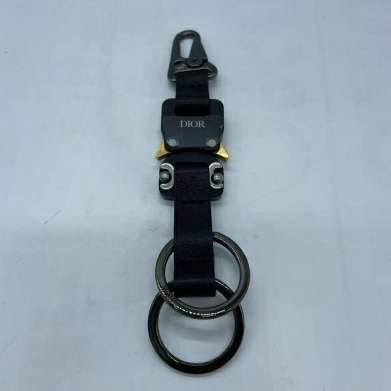 Keyring by Christian Dior: Keyring by Christian Dior Christian Dior's sleek keyring boasts a sophisticated black finish, measuring 16cm in length and 3cm in width. This stylish accessory bears the iconic brand's signature witho