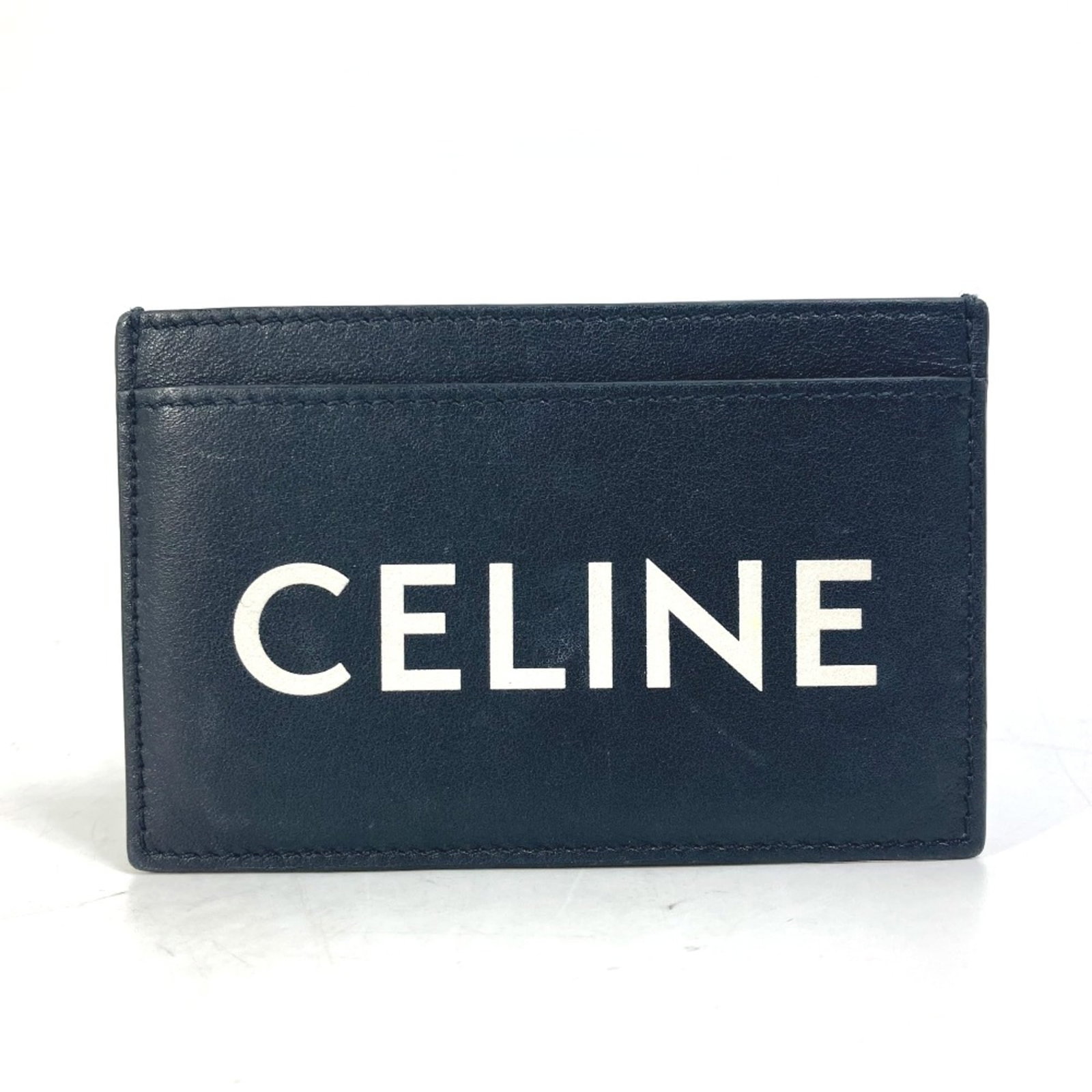 Card case of leather by Celine: Card case of leather by Celine Black leather card case by Celine, measuring 10.5cm x 7cm and 4.1cm x 2.8cm in width and height respectively. Made from high-quality leather, this sleek card case