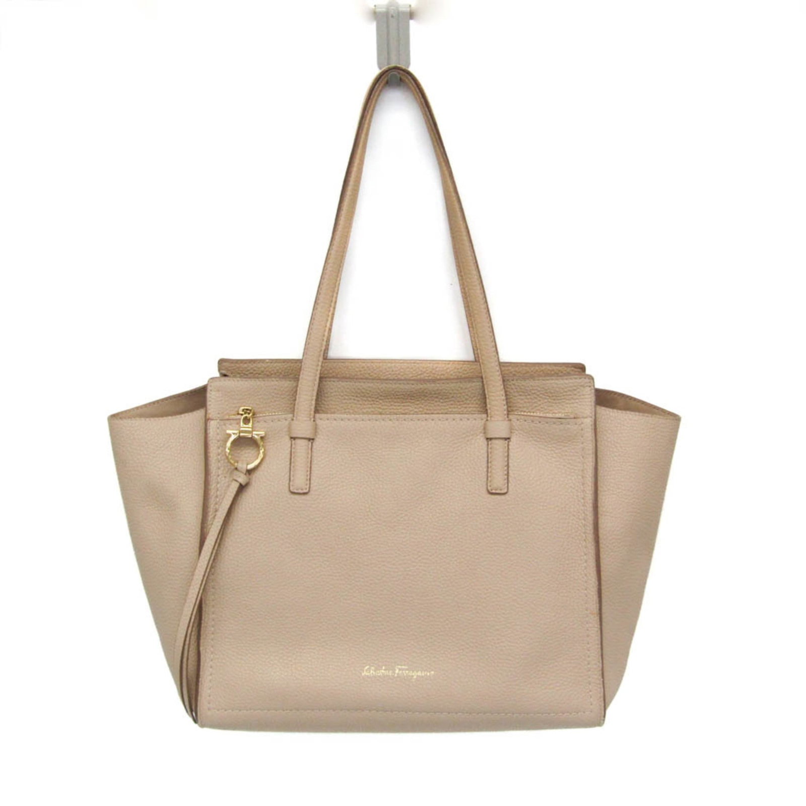 Salvatore Ferragamo Tote Bag Leather: Salvatore Ferragamo Tote Bag Leather Top-quality leather tote bag from Salvatore Ferragamo's Gancini line, featuring iconic GG-21 design. This stylish bag boasts a light beige color, zipper closure,