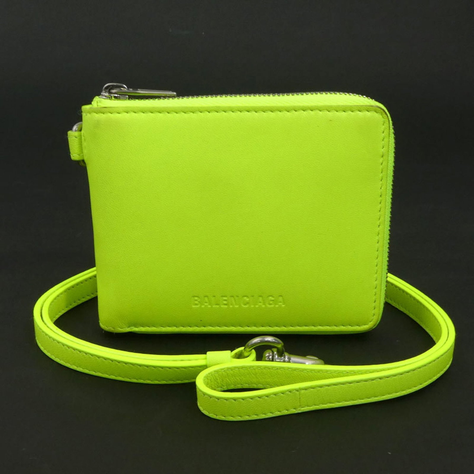 Balenciaga Wallet (Bi-Fold) Leather: Balenciaga Wallet (Bi-Fold) Leather Balenciaga's bi-fold leather wallet features a striking yellow color and sleek design. Made from high-quality leather, its compact size (9cm x 11.5cm x 1.5cm)