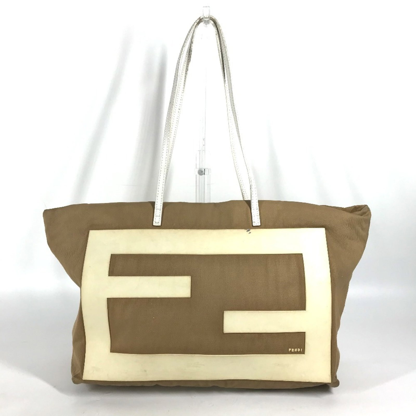 Canvas rubber tote bag by Fendi: Canvas rubber tote bag by Fendi Canvas rubber tote bag by Fendi, featuring a unique blend of canvas and rubber materials in beige and white hues. This stylish shoulder bag boasts a sleek design with