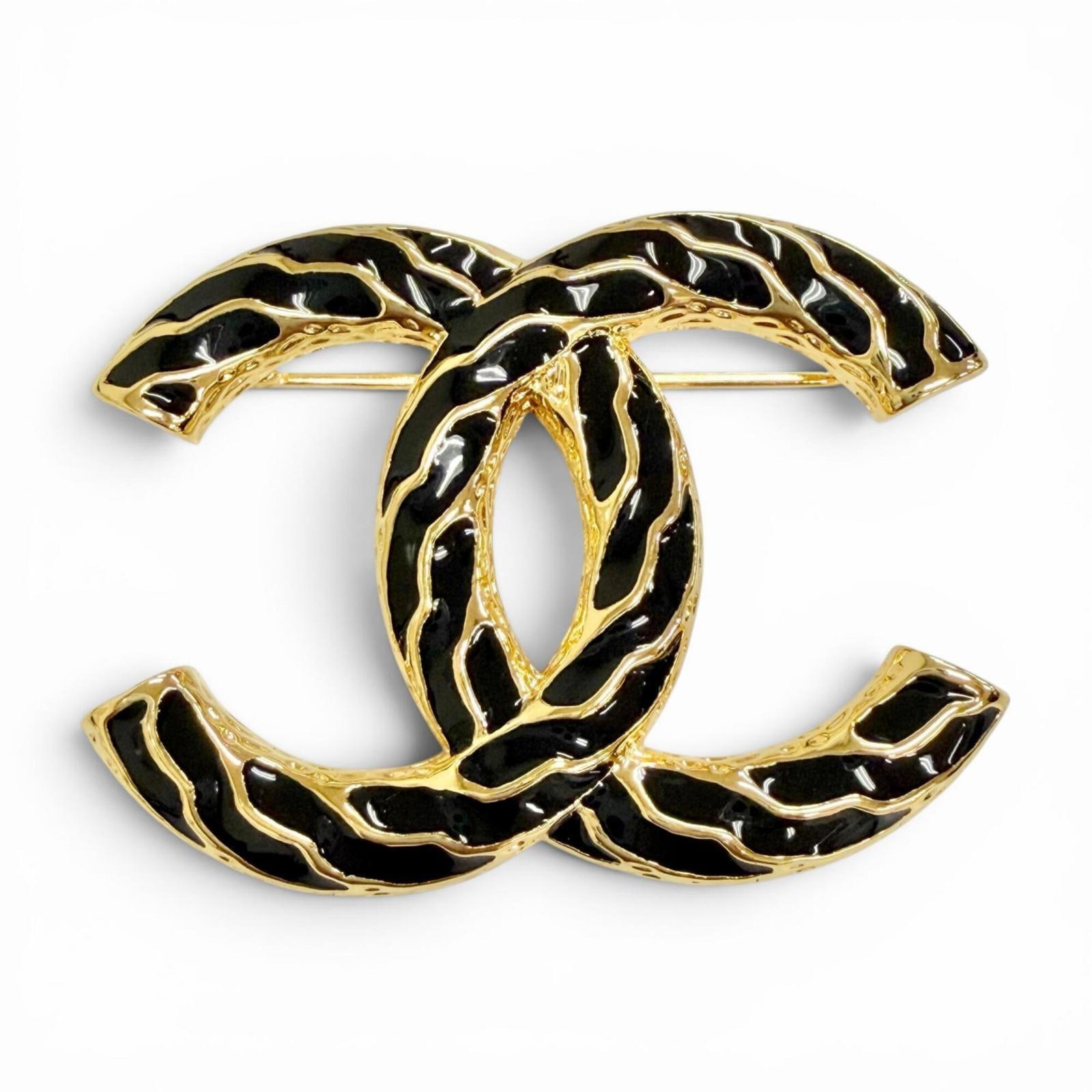 Chanel Brooch: Chanel Brooch The Chanel brooch boasts sleek, modern lines and a striking black finish, complemented by gold accents. Its compact size belies its sophisticated charm, measuring 3.8cm x 5.3cm in dimens