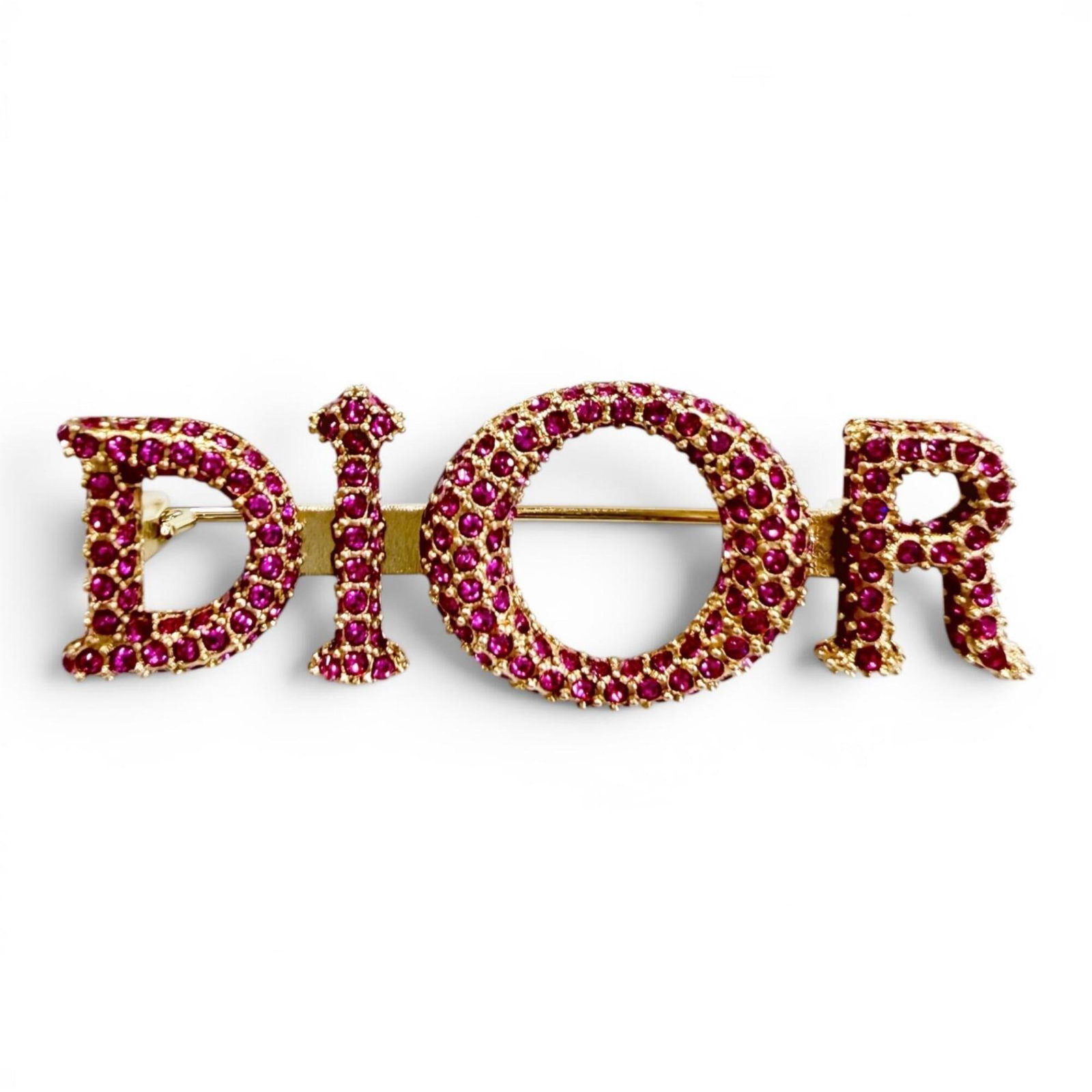 Dior Brooch by Christian: Dior Brooch by Christian Gold and pink rhinestone brooch by Christian Dior, measuring 1.5cm x 4.5cm in size. The piece bears a signature from the artist, adding a touch of elegance to any outfit. A be