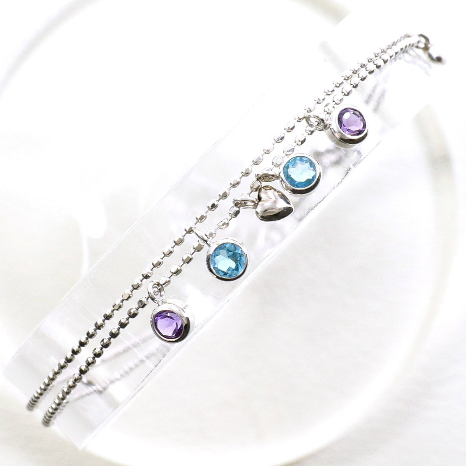 White Gold 18K Unbranded Charm Bracelet: White Gold 18K Unbranded Charm Bracelet White gold (18K) charm bracelet with an elegant combination of amethyst, blue, and white gold stones. This beautifully crafted piece boasts a classic design tha