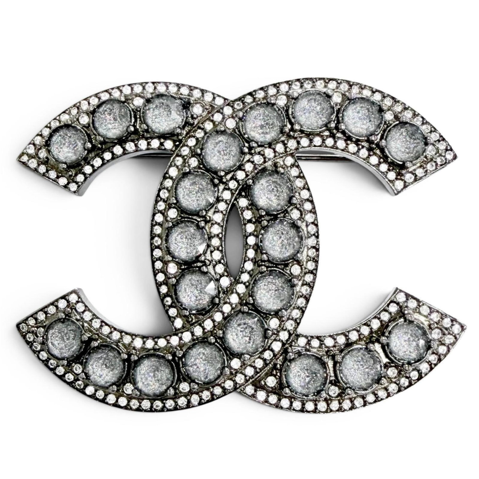Chanel Brooch: Chanel Brooch Silver Chanel brooch featuring rhinestone, measuring 3.5cm x 4.8cm in size. This French-made piece boasts a sleek design with intricate details. A beautiful addition to any jewelry colle