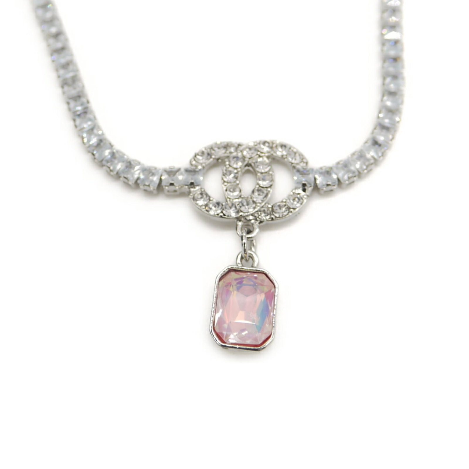 Chanel Pink Crystal Coco Mark Pendant Tennis Necklace: Chanel Pink Crystal Coco Mark Pendant Tennis Necklace The Chanel Pink Crystal Coco Mark Pendant Tennis Necklace boasts a striking pink crystal stone set in metal, measuring 16.3mm x 32.2mm. Weighing