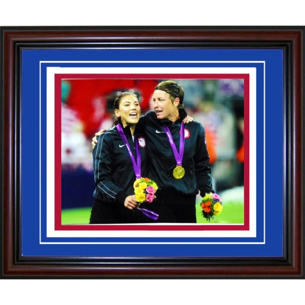 Hope Solo & Abby Wambach Unsigned Framed 11x14 Photo: Hope Solo & Abby Wambach Unsigned Framed 11x14 Photo Hope Solo and Abby Wambach's signed photo, framed in a cherry wood frame with blue matte on white and red matte, makes for a unique addition to any
