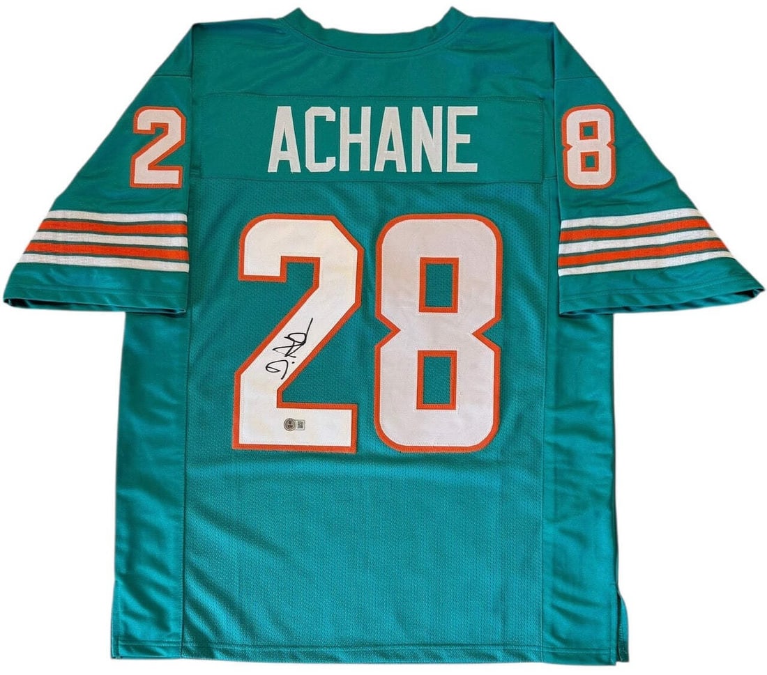 De'Von Achane Autographed Custom Miami Dolphins Jersey (Beckett Witness): De'Von Achane Autographed Custom Miami Dolphins Jersey (Beckett Witness) De'Von Achane's sharpie signature on the back of this custom Miami Dolphins jersey stands out as a unique touch. The Beckett Wi