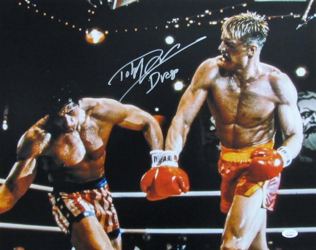 Lundgren Dolph Autographed Photo 16x20 Balboa Drago Inscribed JSA 184769: Lundgren Dolph Autographed Photo 16x20 Balboa Drago Inscribed JSA 184769 Dolph Lundgren's iconic image from the 1987 film Balboa vs Drago is captured in a rare and unique 16x20 photo, bearing his