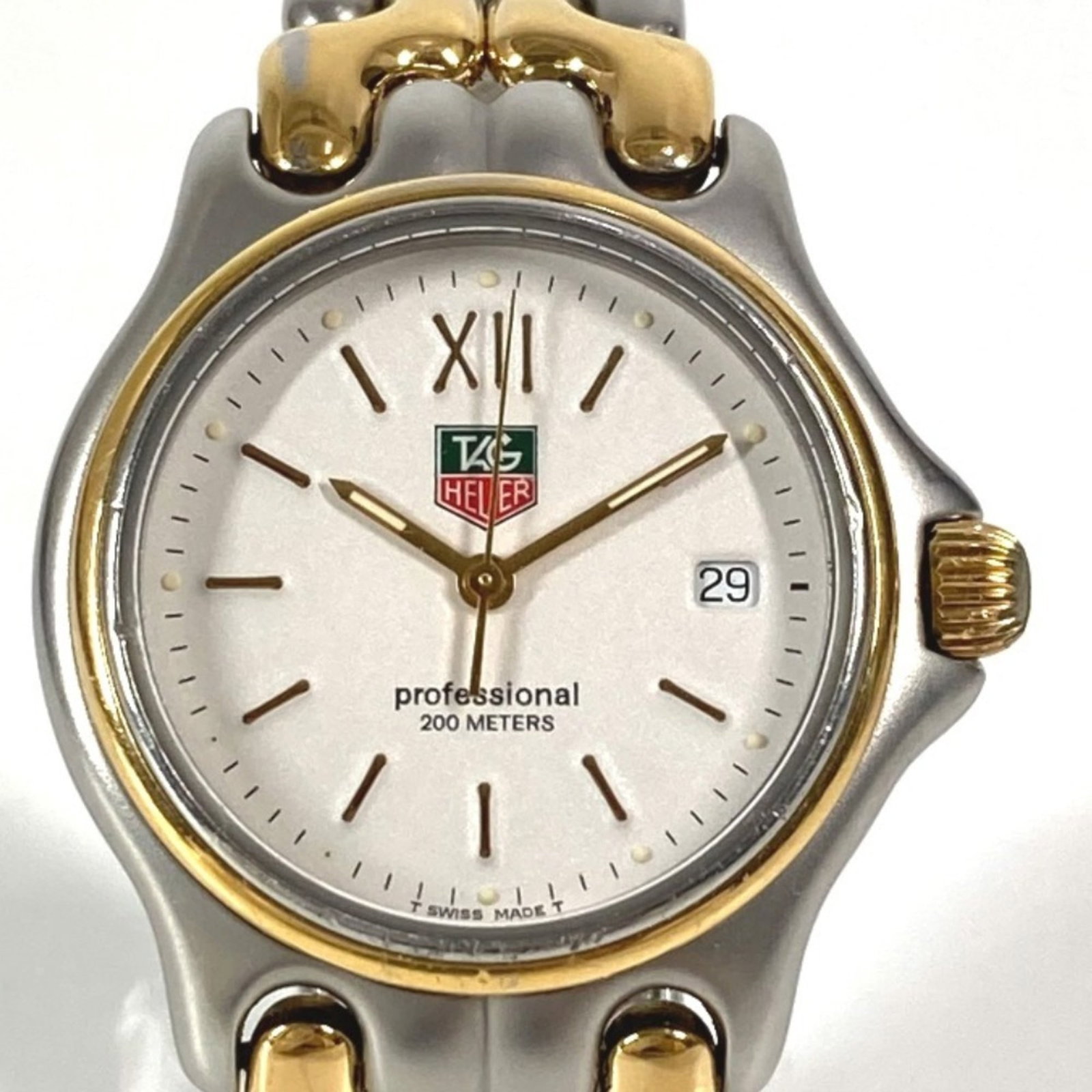 Wristwatch by Tag Heuer: Wristwatch by Tag Heuer Stainless steel case and band provide a sleek, modern look for the Tag Heuer wristwatch. The white dial stands out against its durable background, while quartz movement
