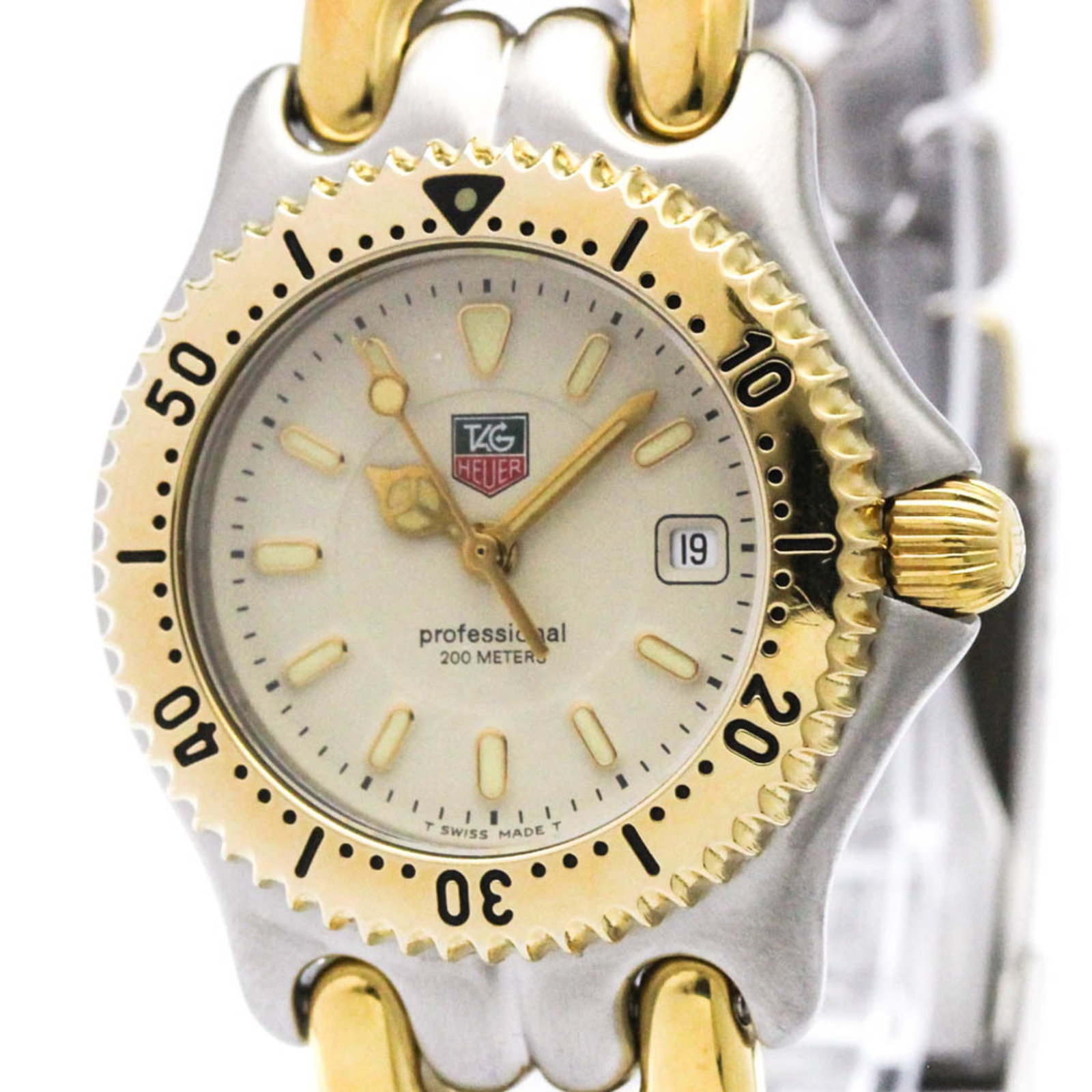Wristwatch by Tag Heuer: Wristwatch by Tag Heuer The Tag Heuer WG1321 wristwatch boasts an elegant ivory dial and gold plated, stainless steel case and band. This refined timepiece features a quartz movement and date