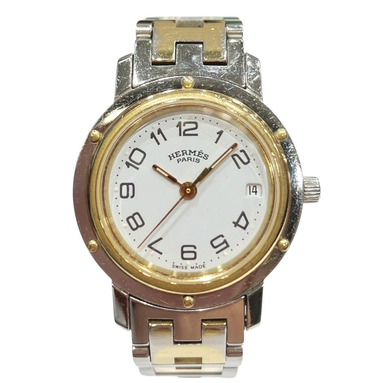 Hermes Wristwatch: Hermes Wristwatch Stainless steel case and band provide a sleek, modern look for this quartz-powered wristwatch. The white dial stands out against the neutral background, adding a touch of elegance to