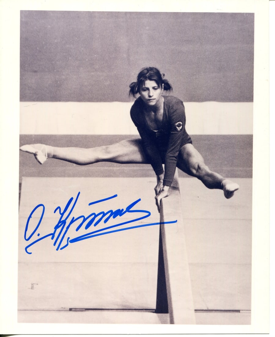 Korbut Olga Autographed Photo 8x10: Korbut Olga Autographed Photo 8x10 Olga Korbut's iconic pose from her abeam routine is captured in this 8x10 photo, signed by the legendary gymnast herself in blue sharpie. The photo bears a