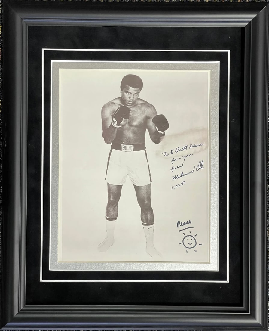 Muhammad Ali Autographed Framed 8x10 Photo: Muhammad Ali Autographed Framed 8x10 Photo Signed in black sharpie across the front of the photo with inscription "To Elliot Kramer from your friend 12-12-87" is Muhammad Ali's signature on a framed 8