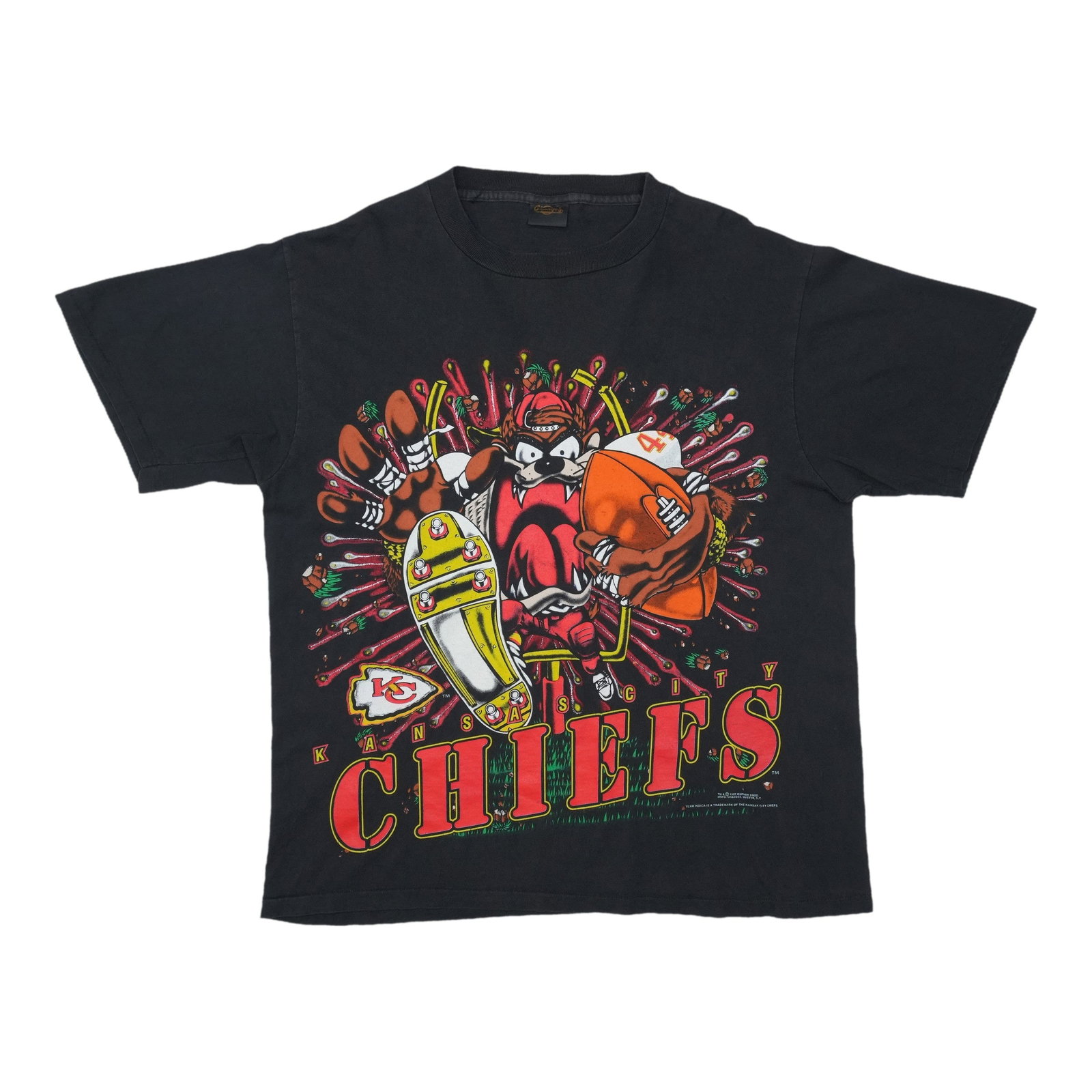 1993 Kansas City Chiefs Tasmanian Devil Shirt: 1993 Kansas City Chiefs Tasmanian Devil Shirt This vintage 1993 Kansas City Chiefs Tasmanian Devil shirt is a nostalgic throwback to the team's wild '90s era. Featuring a bold, cartoon-inspired