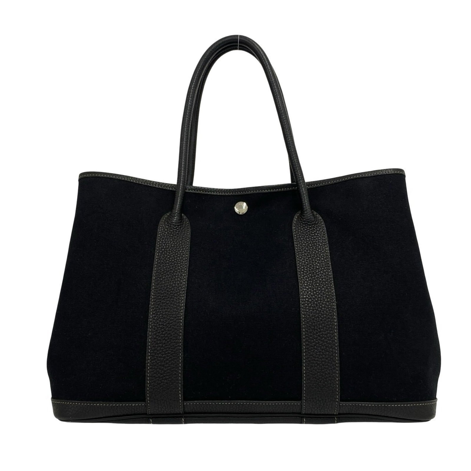 Buffalo Leather Handbag Tote Hermes Toile Officier: Buffalo Leather Handbag Tote Hermes Toile Officier Buffalo leather and Toile Officier fabric come together in this sleek black tote bag from Hermes. Measuring 26cm x 36.5cm x 17.5cm, it features a cla