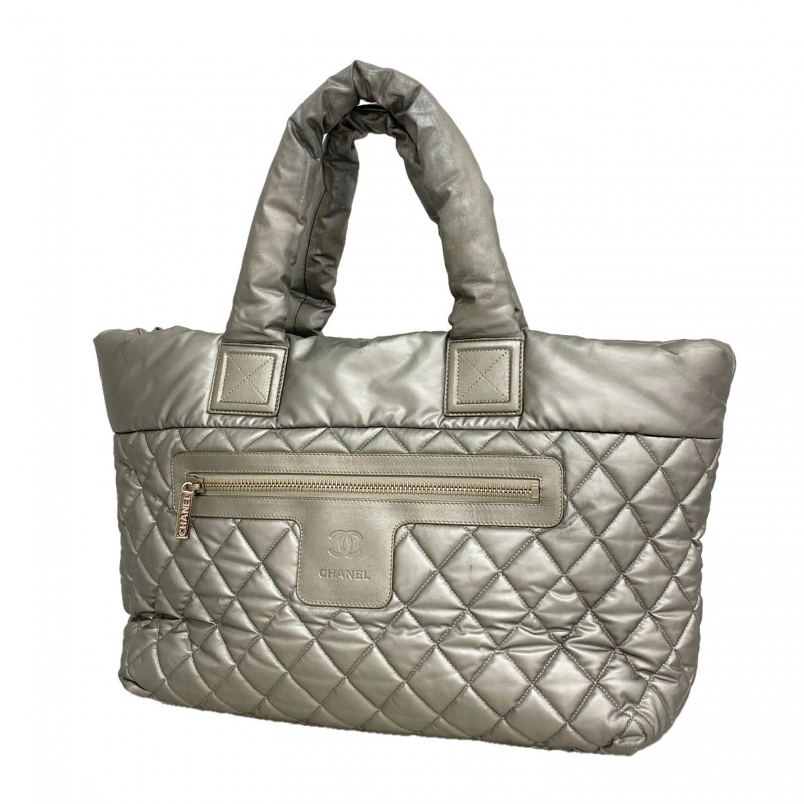 Nylon Tote Bag By Chanel: Nylon Tote Bag By Chanel Nylon Tote Bag By Chanel is made from high-quality nylon material and features a sleek gray color with silver hardware, adding a touch of sophistication to any outfit. The bag