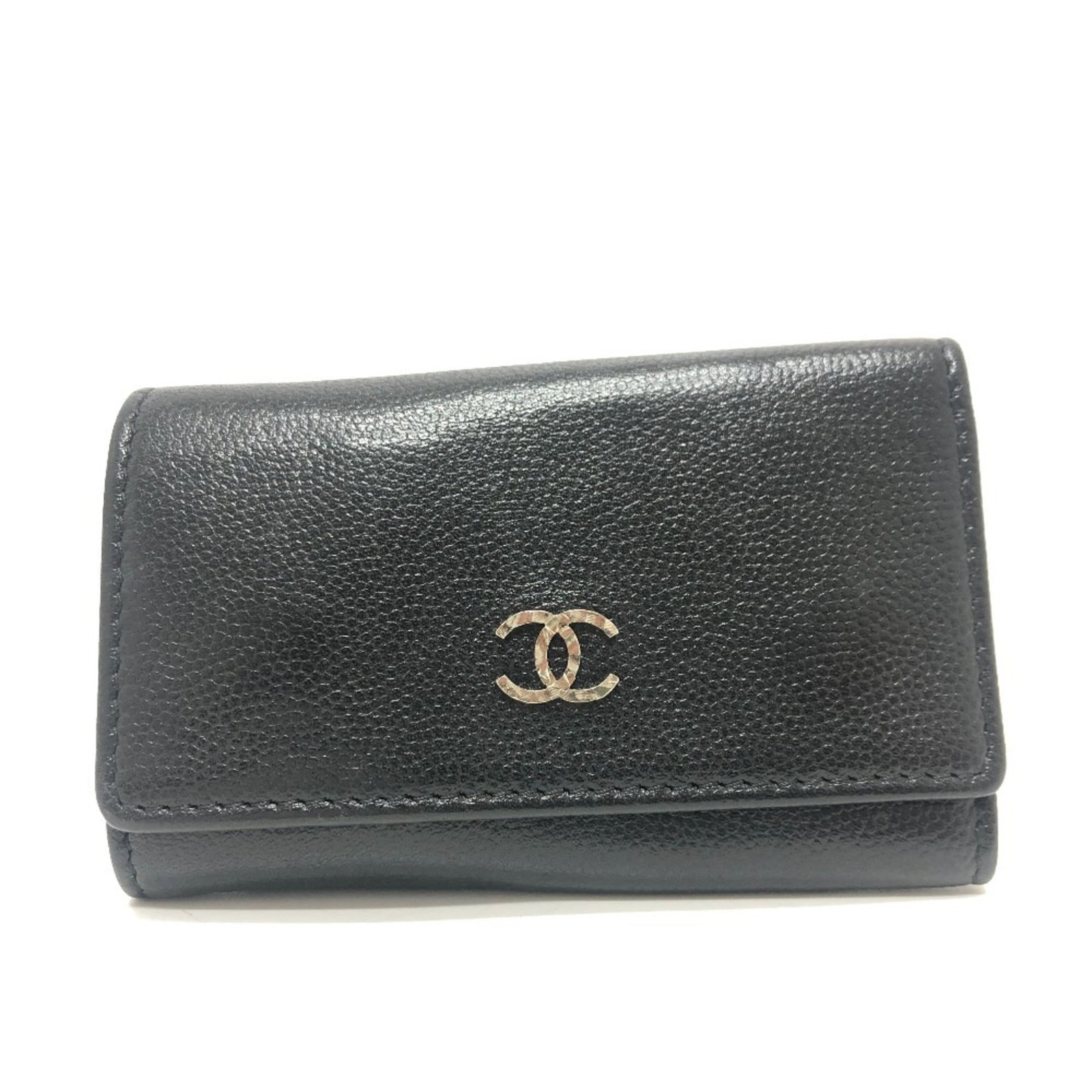 Keycase leather by Chanel: Keycase leather by Chanel Black leather keycase by Chanel, measuring 7cm x 10.5cm, comes with a guarantee card. This stylish keycase is made from high-quality leather, providing a sleek and sophistica