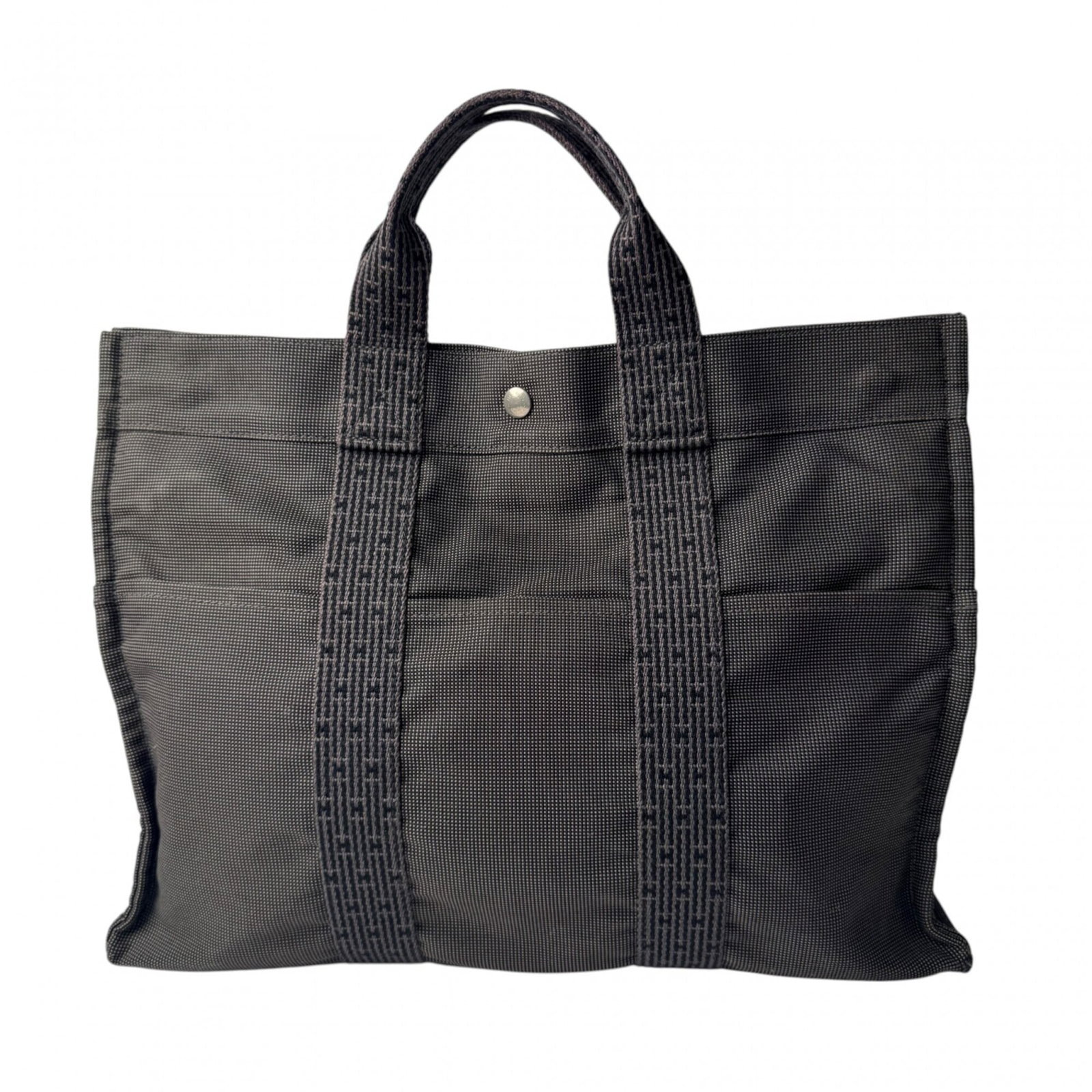 Canvas tote bag Hermes: Canvas tote bag Hermes Canvas tote bag from Hermes, featuring a sturdy canvas material and a gray color. Measuring 31cm x 42cm x 10cm, this bag is designed to carry essentials in style. The bag bears