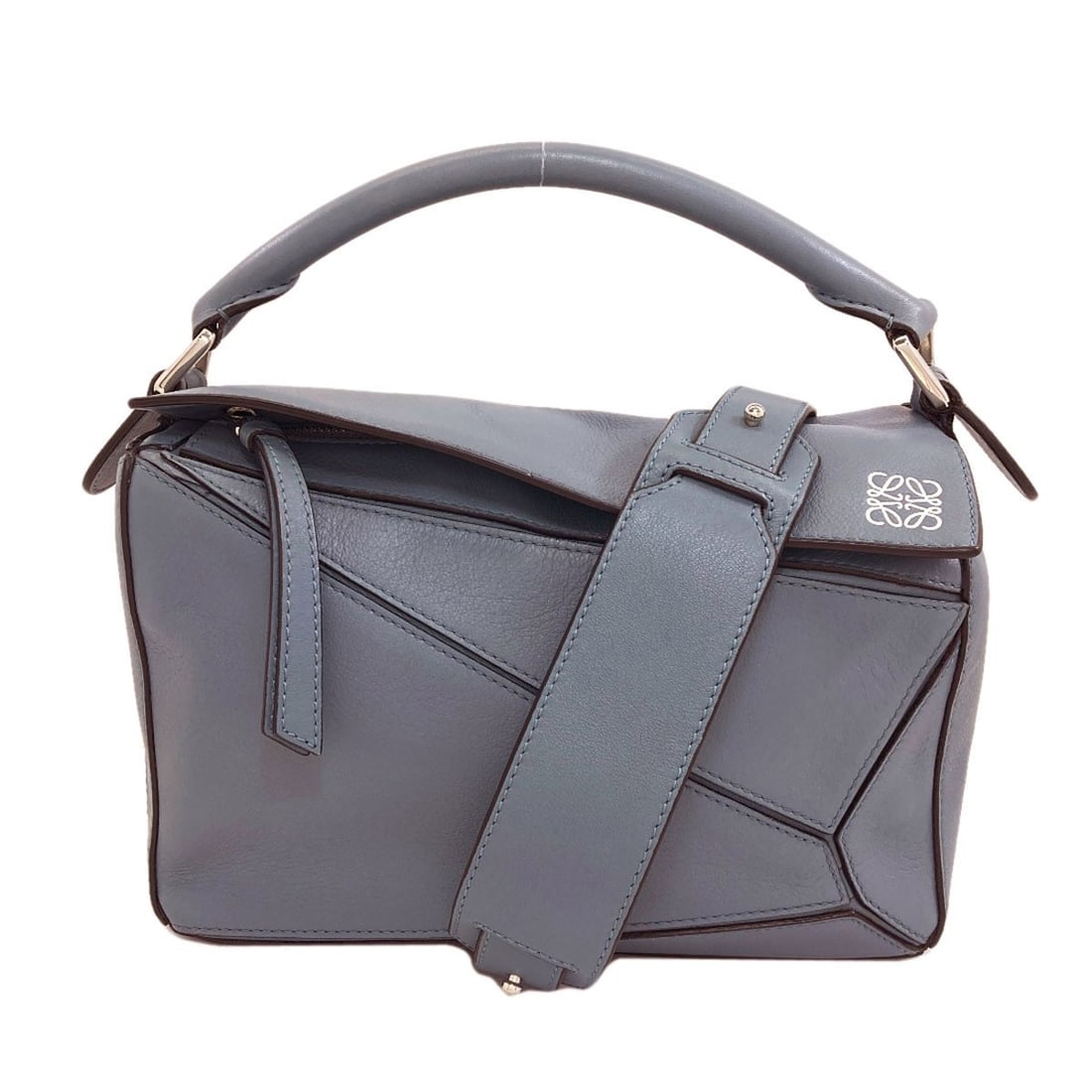 Loewe Puzzle Bag 2Way Handbag Calf: Loewe Puzzle Bag 2Way Handbag Calf Blue Loewe Puzzle Bag 2Way Handbag in Calf Leather. This stylish 6.1-inch blue handbag features a 9.4-inch width, 4.1-inch depth, and is closed with a zip. The