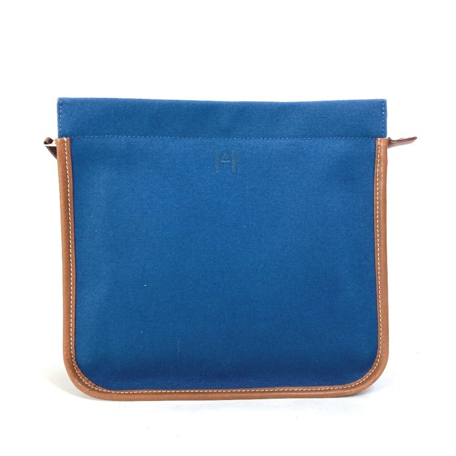 Hermes leather canvas bag pouch: Hermes leather canvas bag pouch Brown and navy canvas and leather bag pouch from Hermes, featuring an open inner pocket and dust bag for storage. Measuring 22.5cm x 24cm x 8.85'' x 9.44'', this