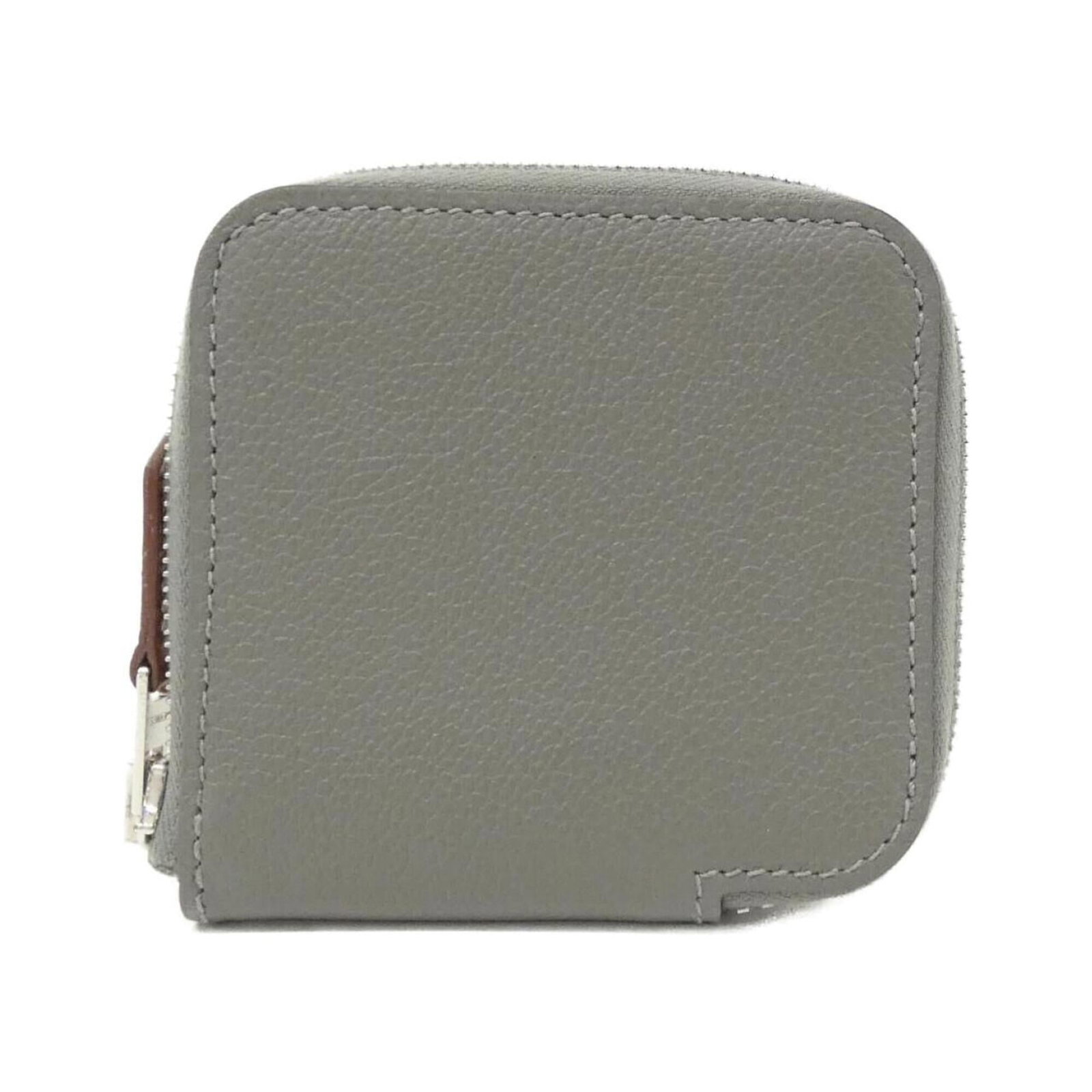 Coin purse silk Hermes: Coin purse silk Hermes Silk from the renowned French fashion house Hermes, this compact coin purse boasts a sleek gray color and a sophisticated 8cm x 8cm x 1cm design. Made from luxurious silk, its