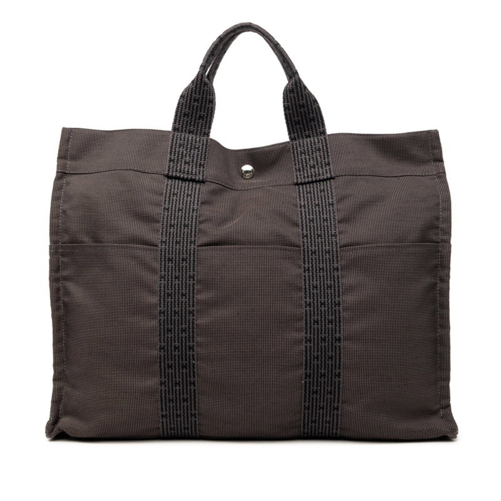 Handbag Tote Bag Canvas Hermes: Handbag Tote Bag Canvas Hermes Canvas tote bag from the Hermes Line, featuring a black and gray color combination. Measuring 32cm x 42cm x 10cm, this handbag is made from canvas material. The bag