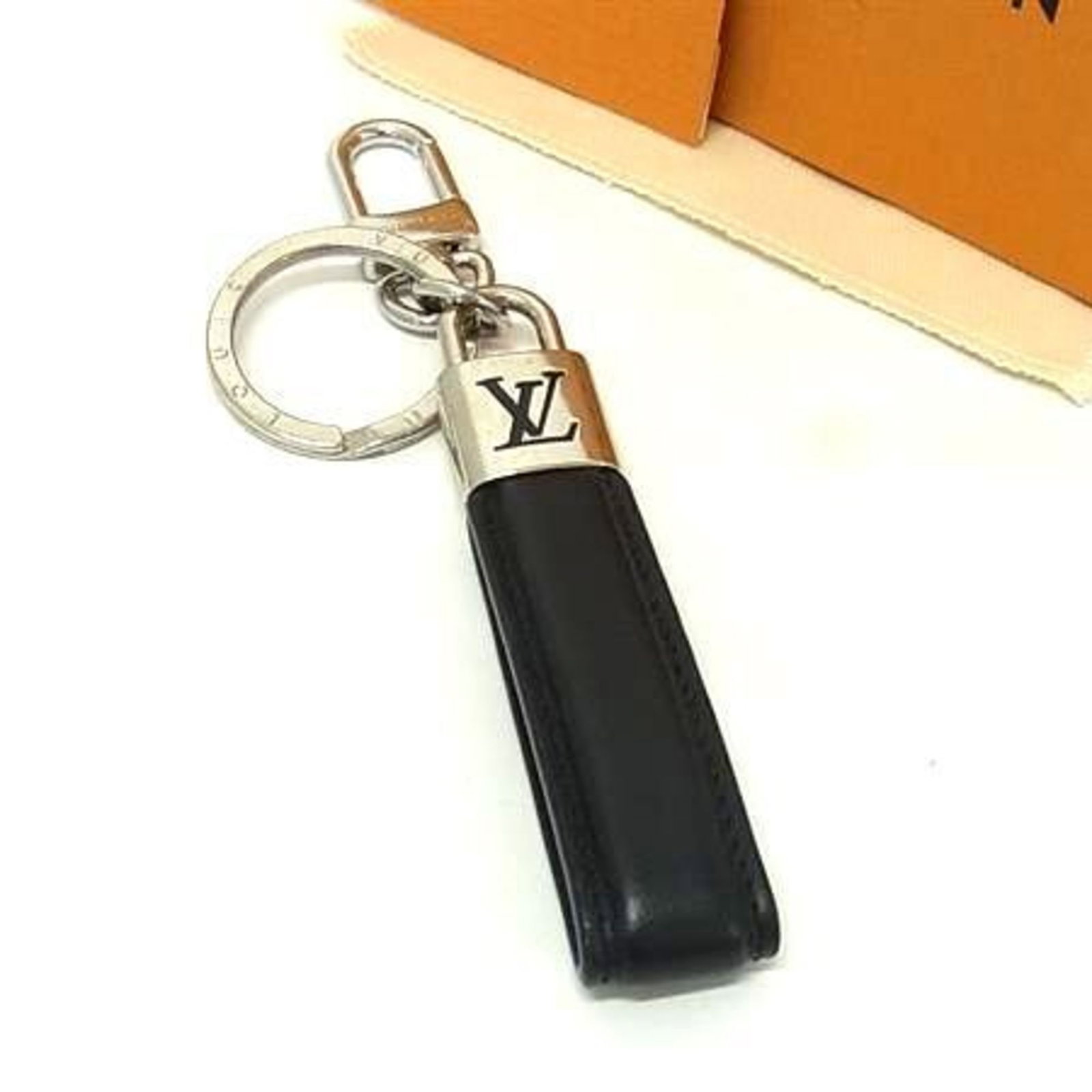 Metal Leather Keyring Louis Vuitton: Metal Leather Keyring Louis Vuitton Black leather and metal keyring from Louis Vuitton, Italy, featuring a classic design with a 15.5cm long chain and a 3.8cm wide metal ring. Comes with a box and dus